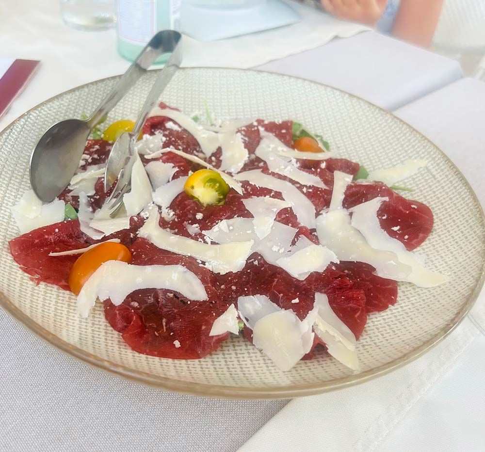 Un plato de comida con una cuchara y un tenedor sobre una mesa.