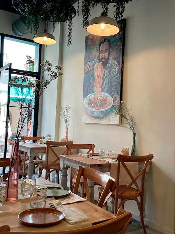 Un restaurante con mesas y sillas y un cuadro en la pared.