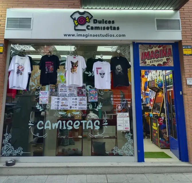 Fachada de Dulces Camisetas con camisetas expuestas en el escaparate y una colorida entrada tipo galería a la derecha.
