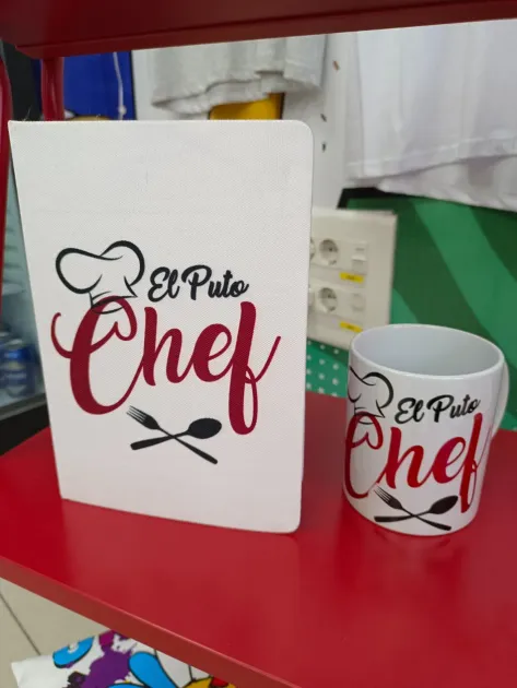 Un cartel blanco con temática de chef y una taza a juego sobre un mostrador rojo, con la inscripción 
