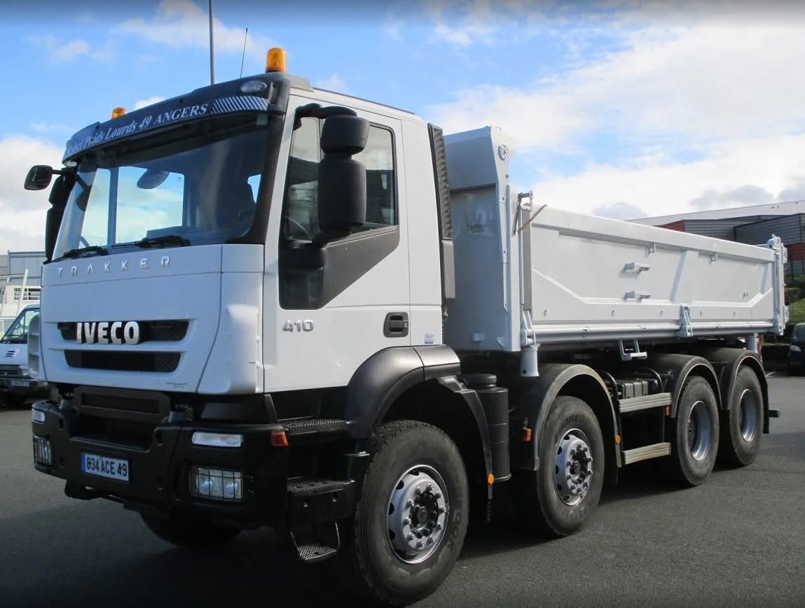 Camion-benne blanc garé à l'extérieur sous un ciel bleu