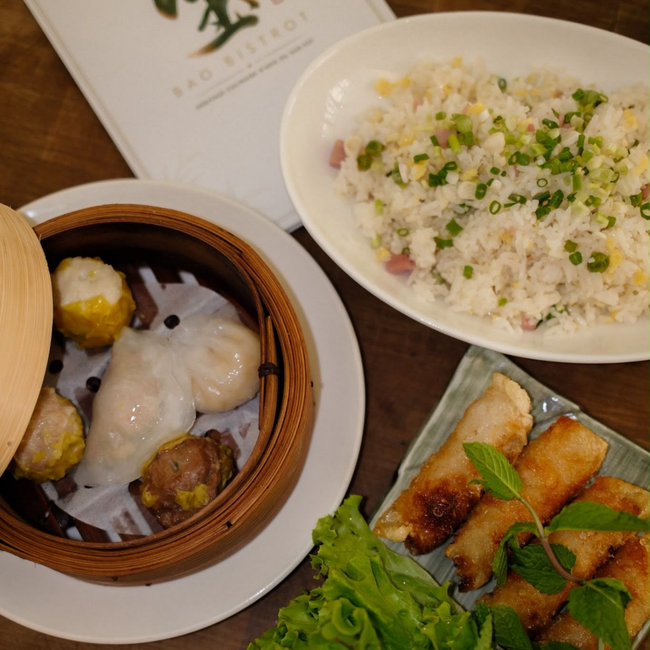 Panier de dim sum, riz frit et brochettes grillées sur une table de restaurant
