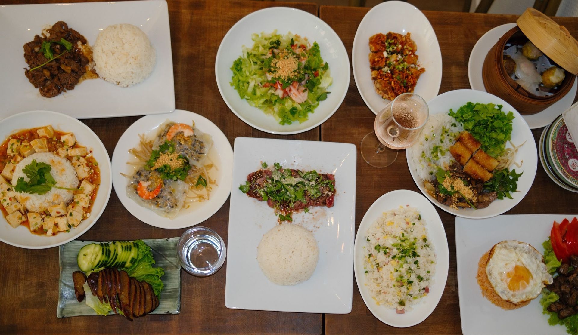 Assortiment de plats et de riz disposés sur une table en bois, comme un repas.