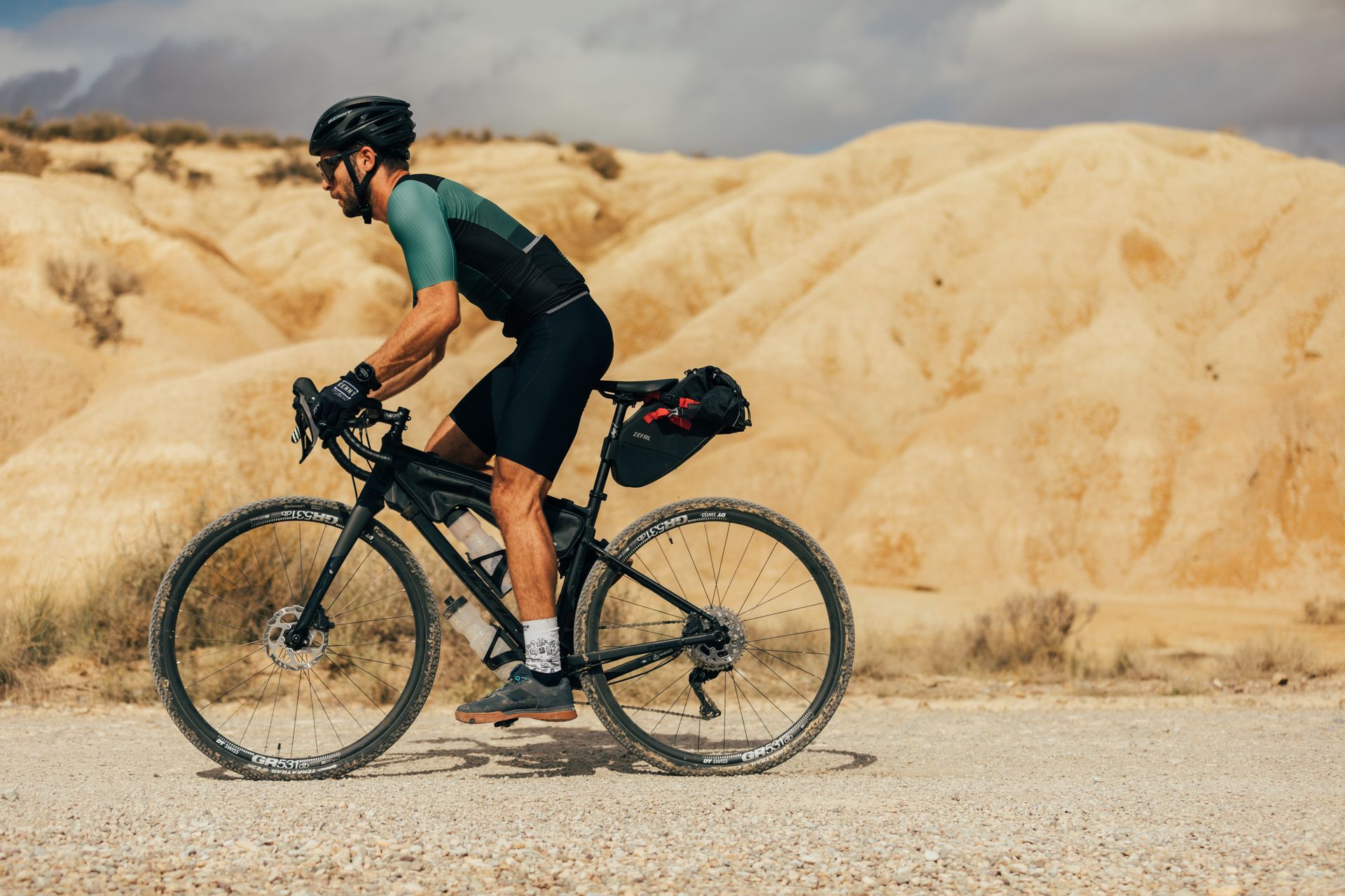 Un homme avec casque et gants roule sur un vélo gravel