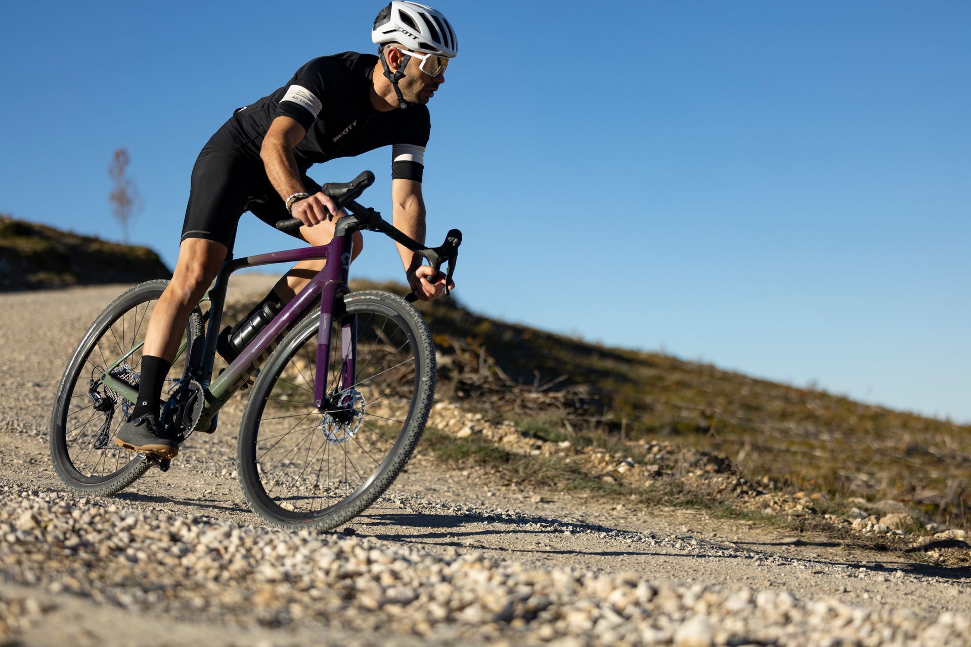 Un homme roule sur un gravel bike sur un terrain accidenté
