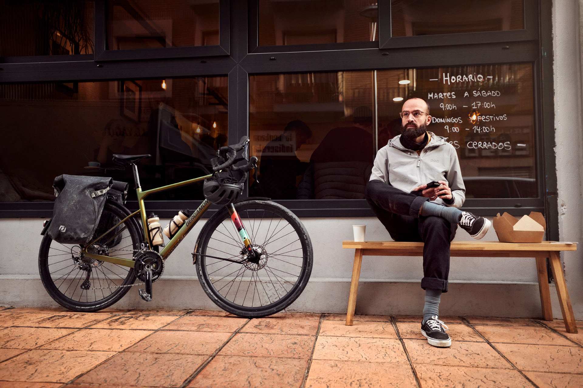 Un homme assis sur un banc avec son vélo de randonnée