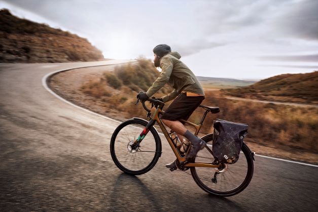 Un homme roule sur un vélo de randonnée avec un casque et des gants