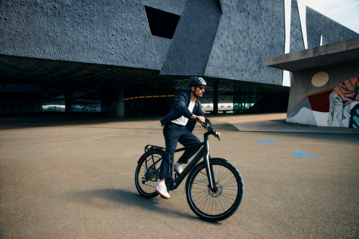 Une homme se promène en ville avec son vélo
