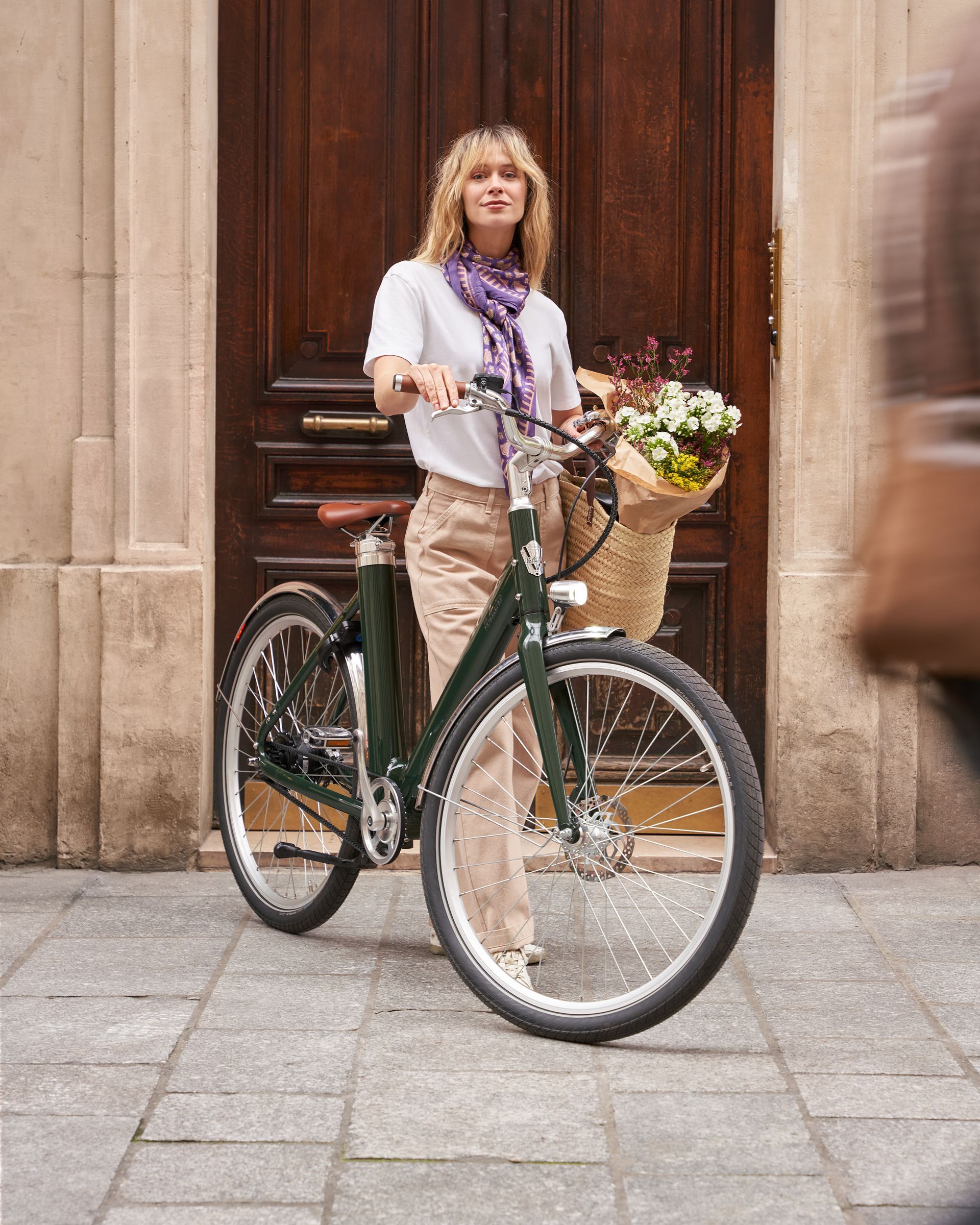 Une femme avec un bouquet de fleurs et un VAE urbain