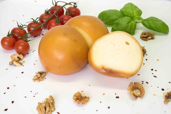 Scamorza affumicata dal colore ambrato con pomodori basilico e noci