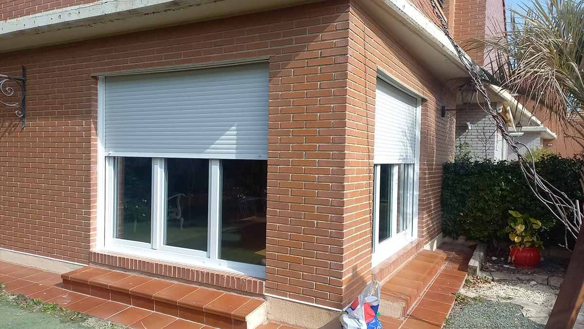 Un edificio de ladrillo con una persiana blanca en la ventana.