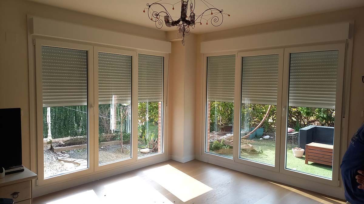 Una sala de estar con muchas ventanas y una lámpara de araña.