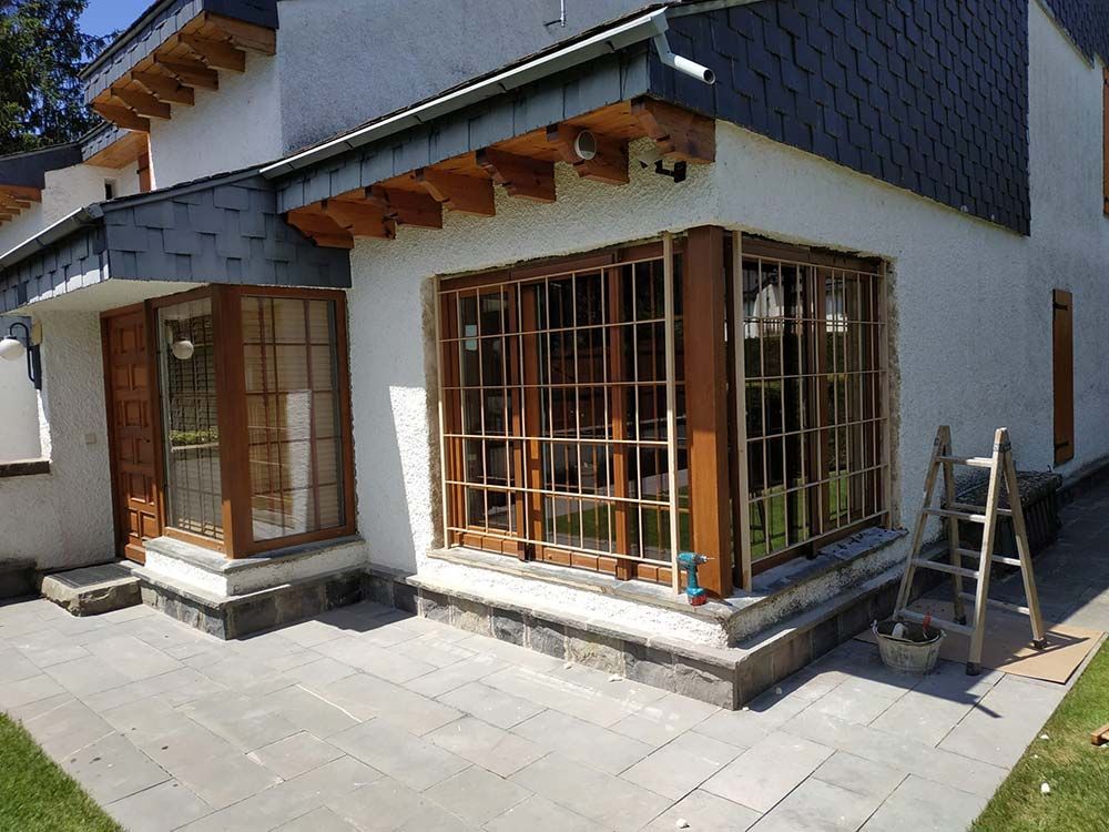 Una casa con muchas ventanas y una escalera delante de ella.