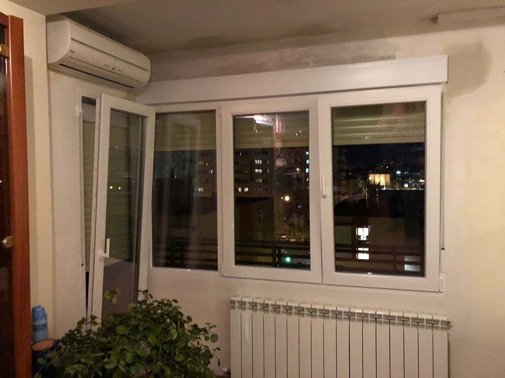 Una sala de estar con radiador y una ventana con vista a la ciudad de noche.