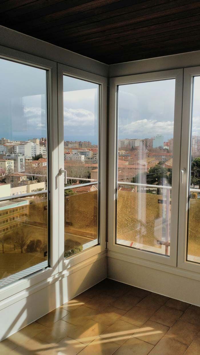 Una habitación con muchas ventanas y vistas a una ciudad.