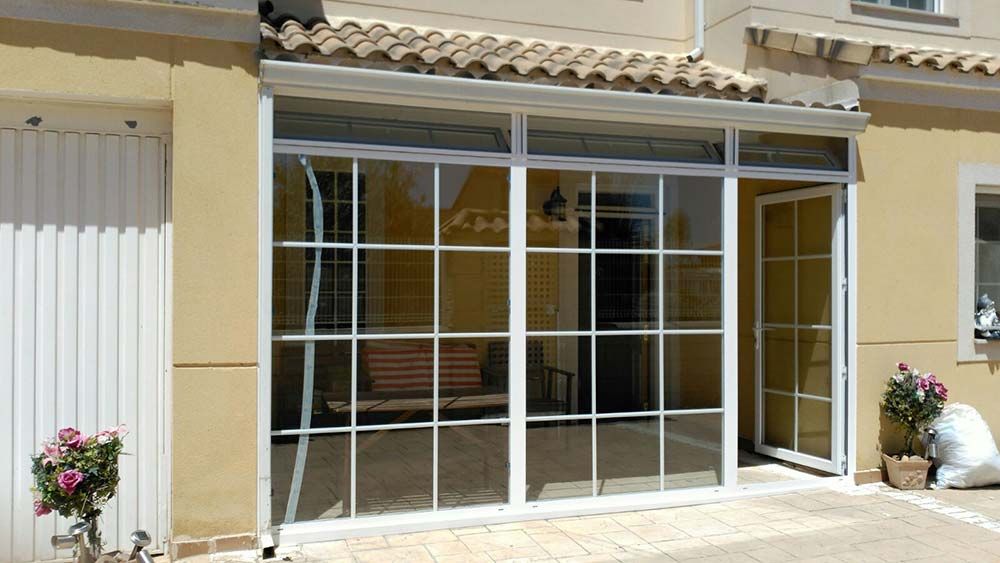 Una casa con muchas ventanas y flores en el frente.