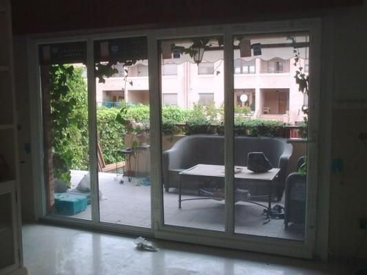 Una sala de estar con puertas corredizas de vidrio que conducen a un balcón.