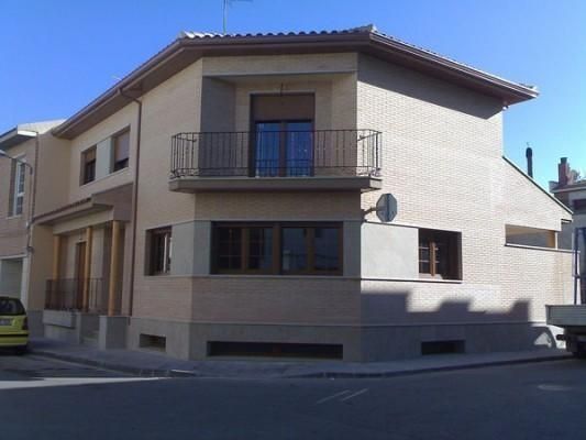 Una casa con balcón en la esquina de una calle