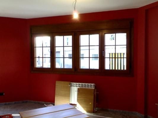 Una habitación con paredes rojas y una gran ventana.
