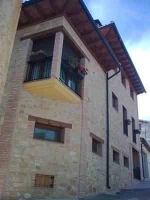 Un gran edificio de ladrillo con un balcón en el costado.