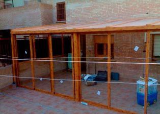 Una estructura de madera con puertas corredizas de vidrio y techo.