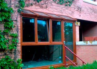 Un edificio de ladrillo con una gran ventana y escaleras que conducen a él.