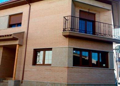 Una casa con balcón y muchas ventanas