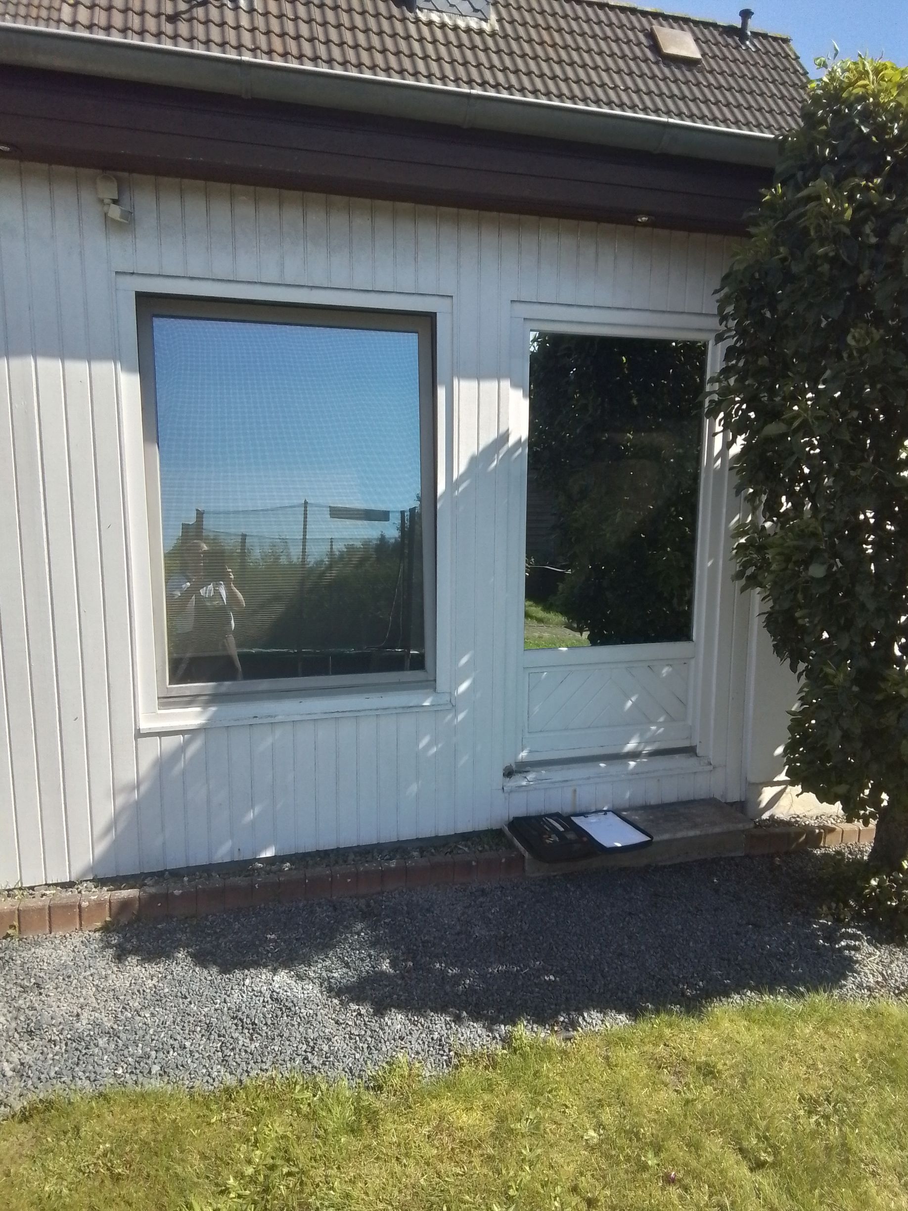 Ein weißes Haus mit einem großen Fenster und einer Tür