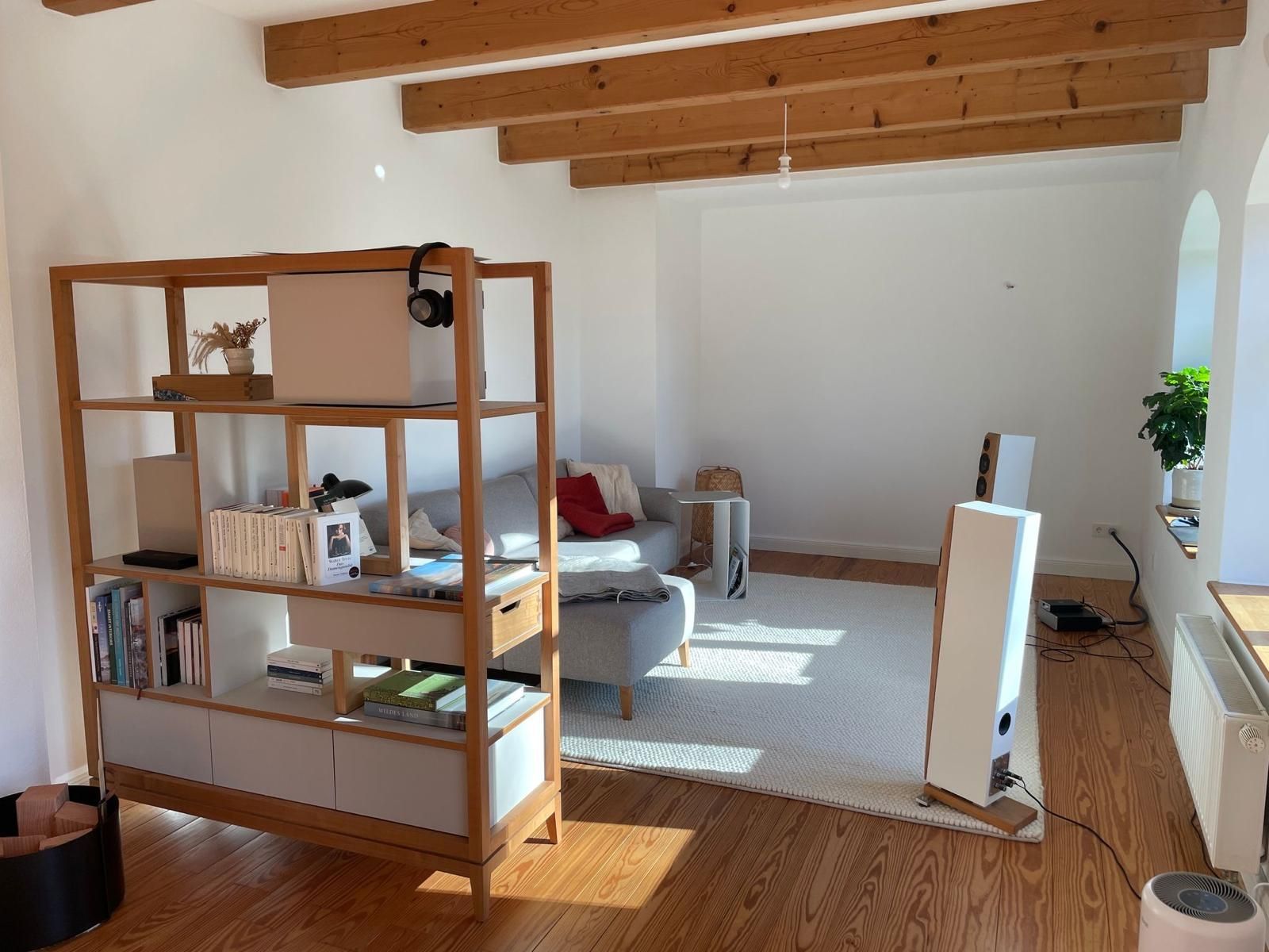 Ein Wohnzimmer mit einem Holzregal und einer Couch