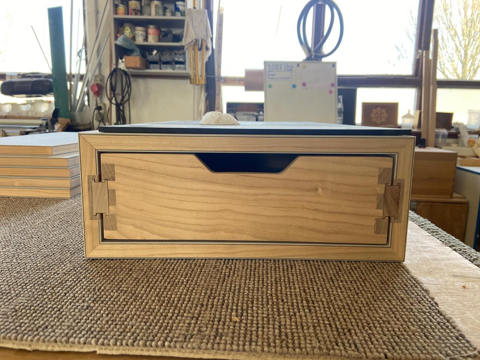 Eine Holzkiste mit einer Schublade steht auf einem Tisch
