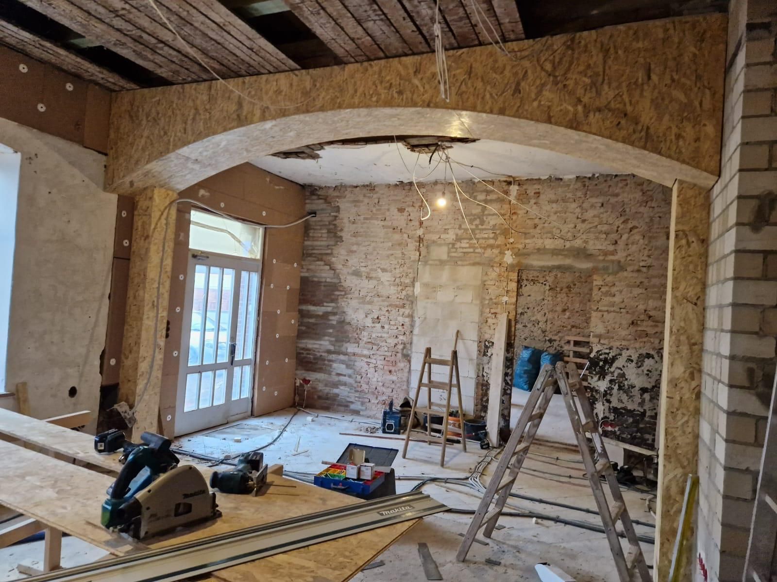 Ein im Bau befindlicher Raum mit einem Holztisch und einer Leiter.