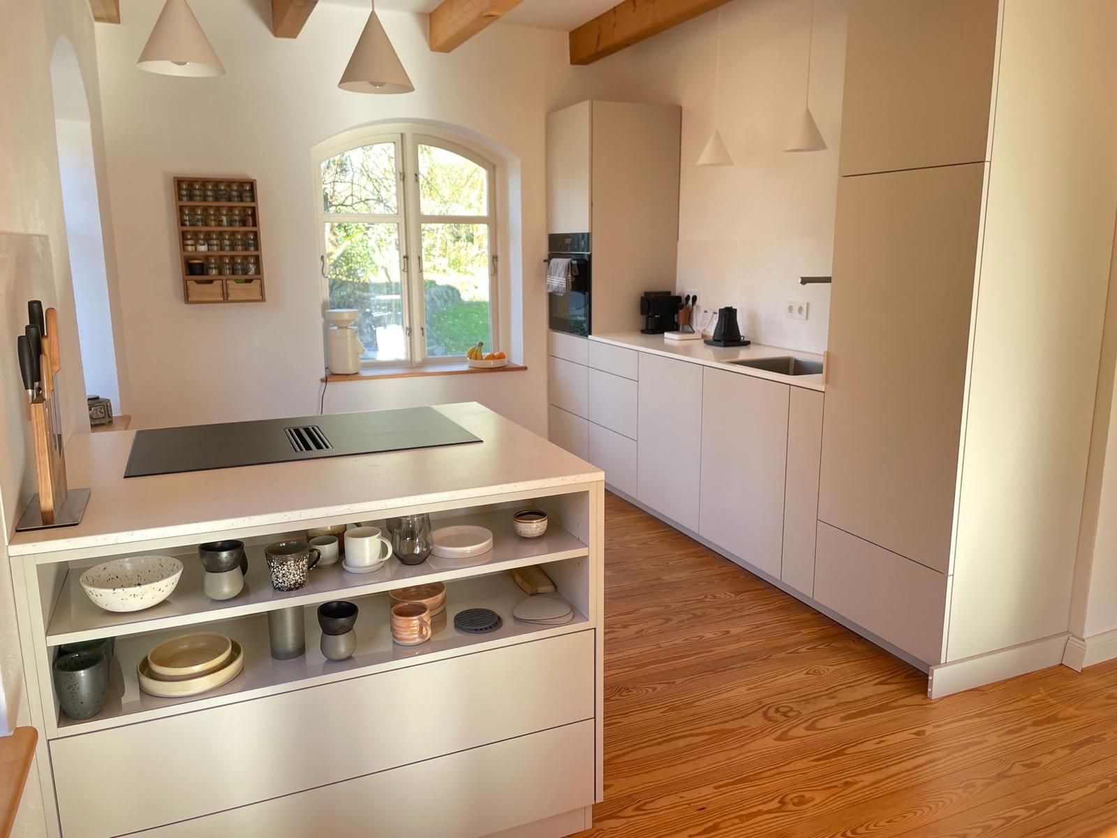 Eine Küche mit weißen Schränken und einer großen Insel in der Mitte.