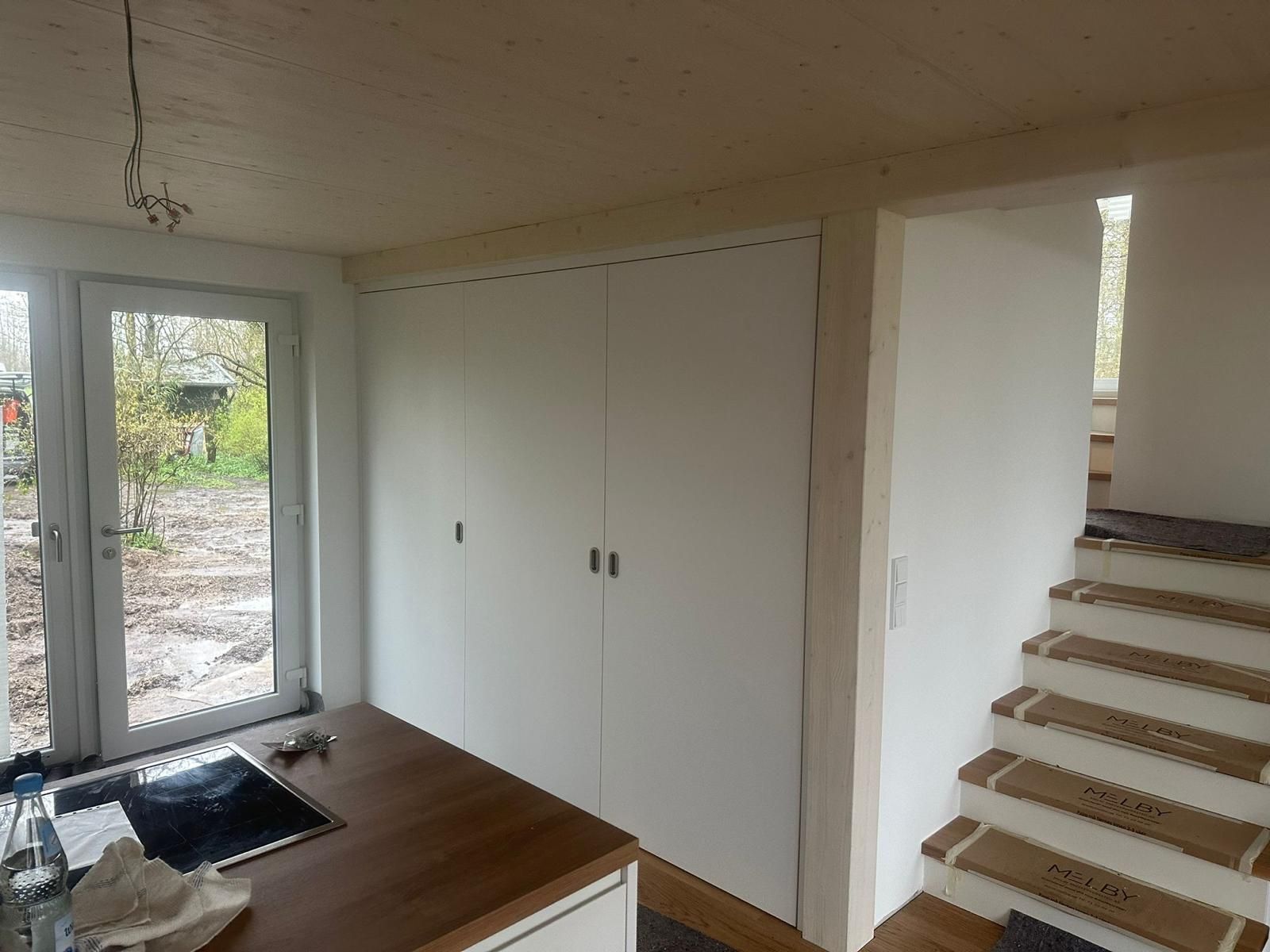 Eine Küche mit Herd und Backofen und Treppen im Hintergrund.