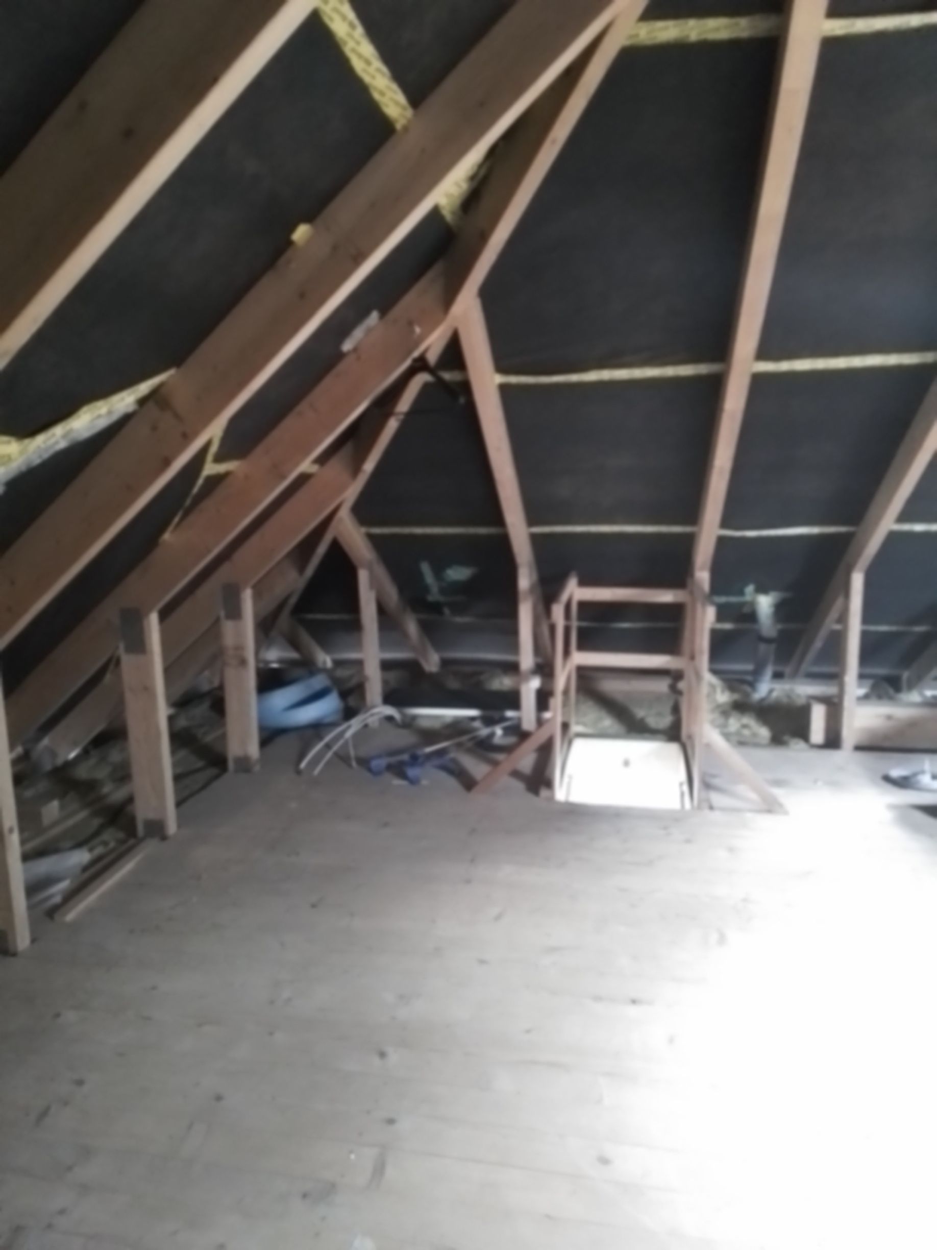 Ein Dachboden mit Holzbalken und einer Leiter