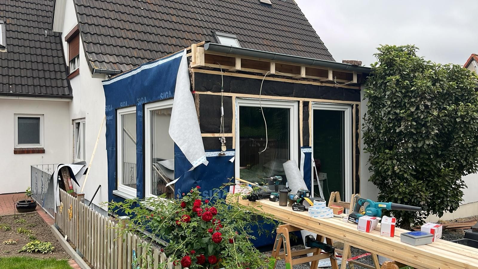 Ein Haus wird umgebaut und davor steht ein Holztisch.