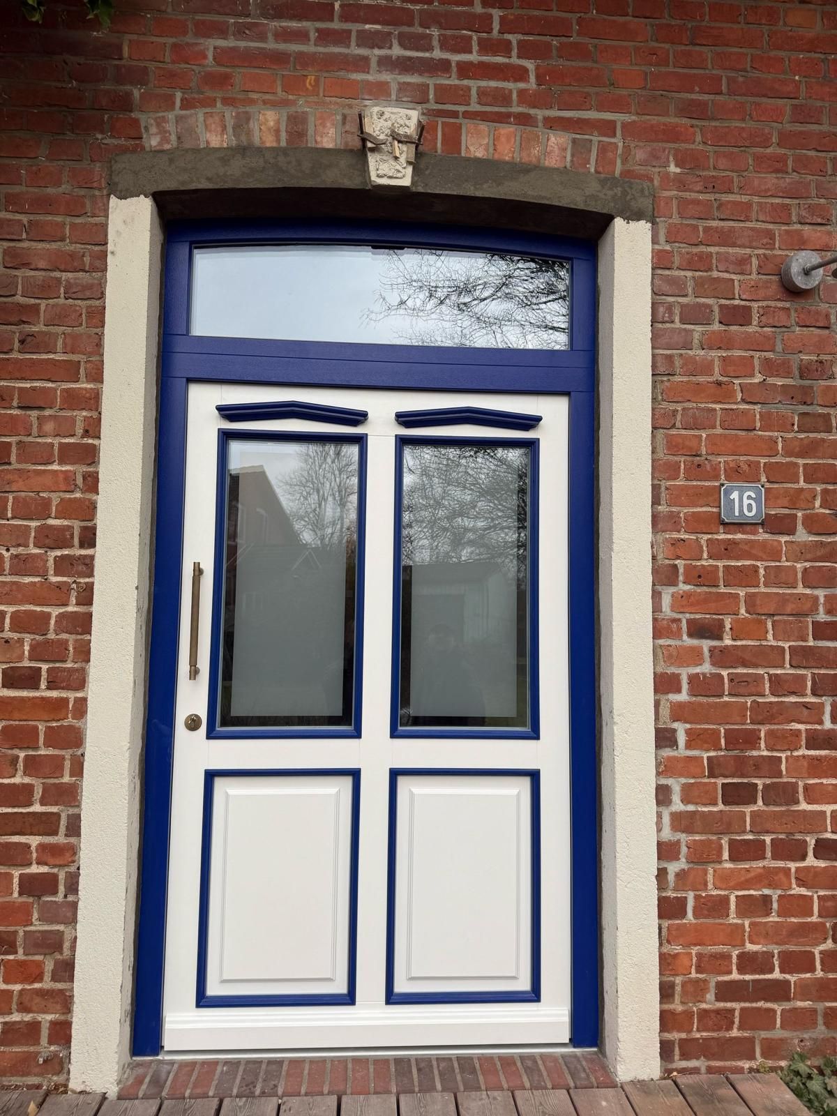 Eine blau-weiße Tür an einem Backsteingebäude