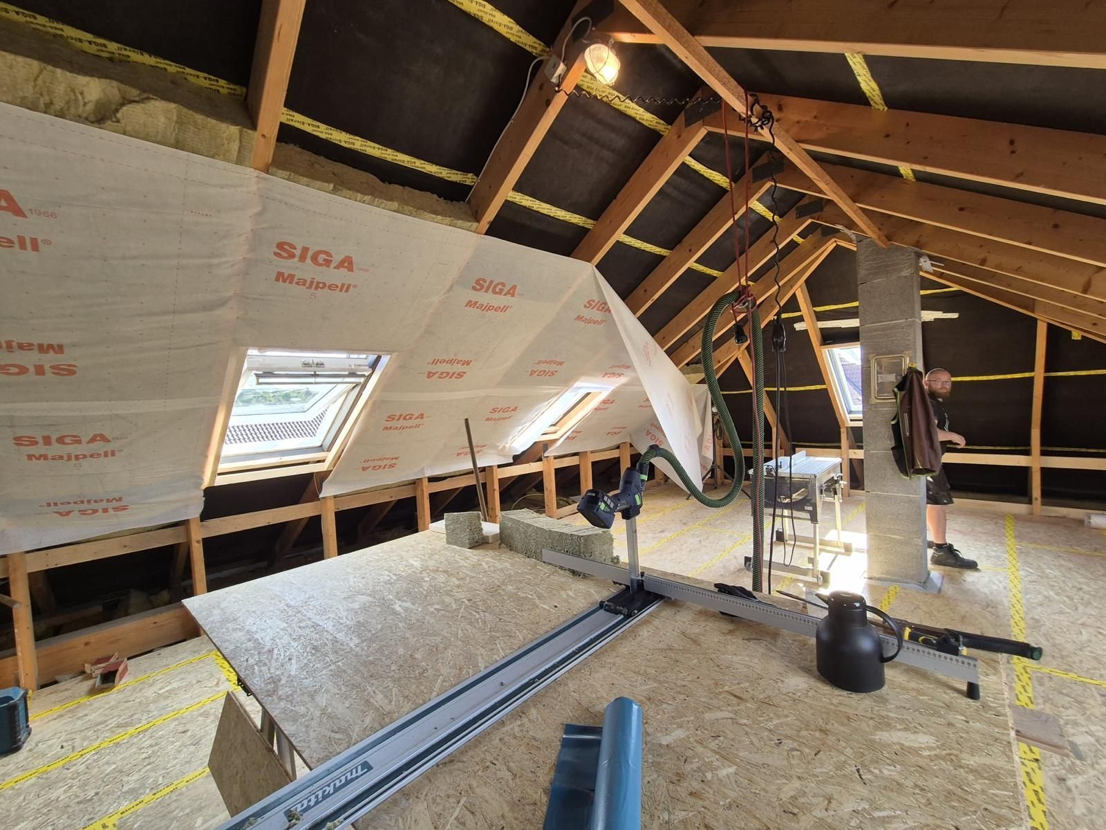 Ein Mann steht auf dem Dachboden eines Hauses.