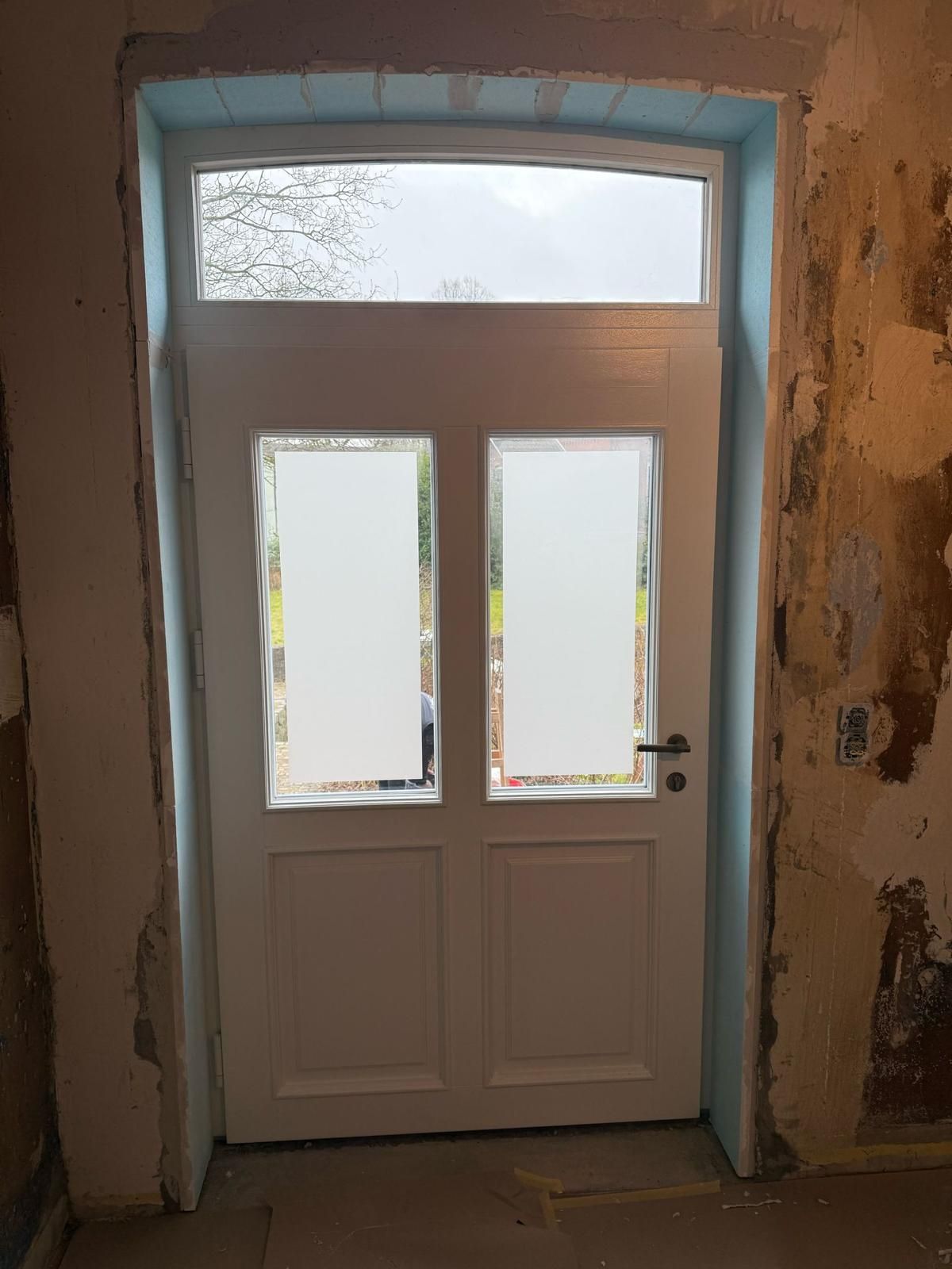 Eine weiße Tür mit zwei Fenstern in einem Raum.