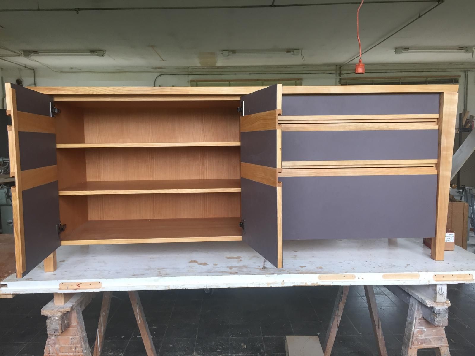 Auf einem Tisch steht ein Holzschrank mit Schubladen und Regalen.