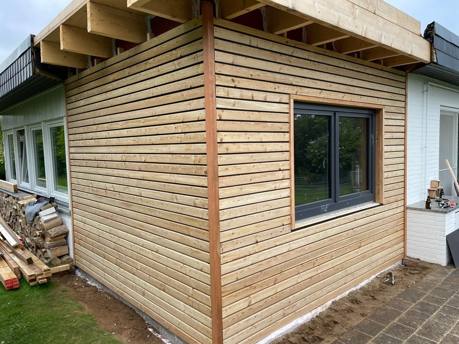Ein Holzgebäude mit einem Fenster an der Seite.
