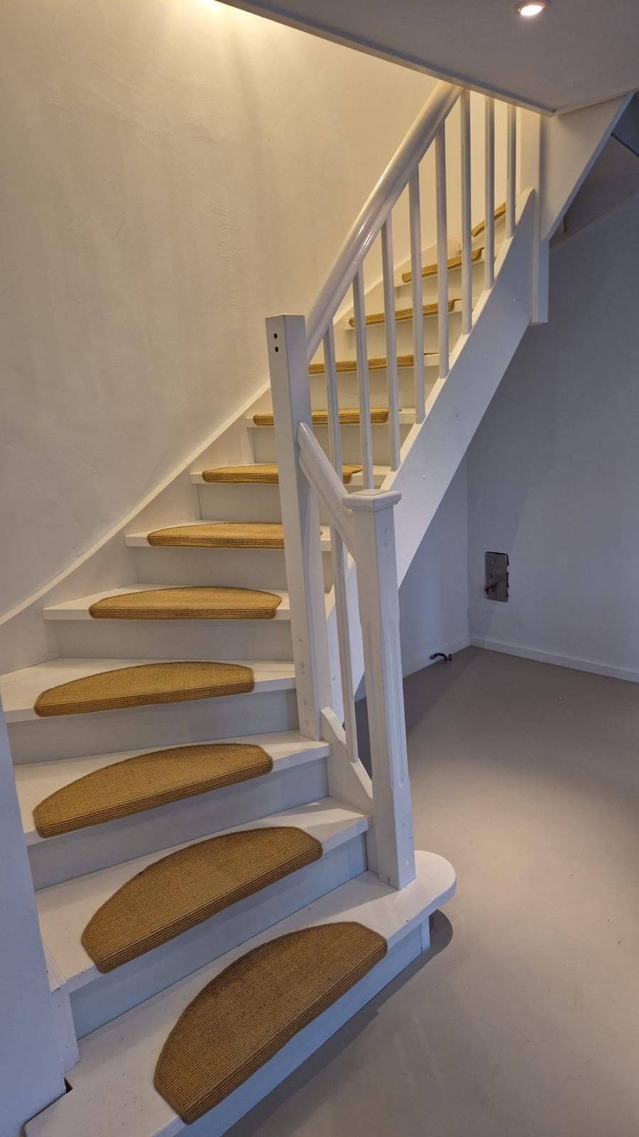 Eine weiße Treppe mit geflochtenen Stufen in einem Zimmer.