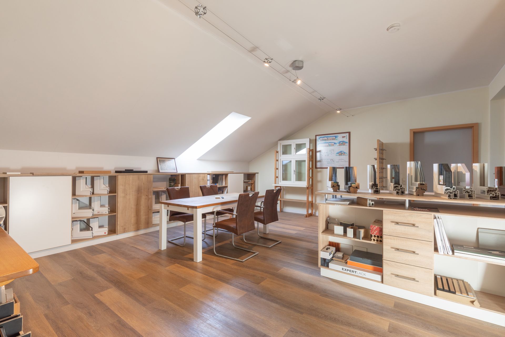 Ein großer Raum mit einem Tisch und Stühlen darin.