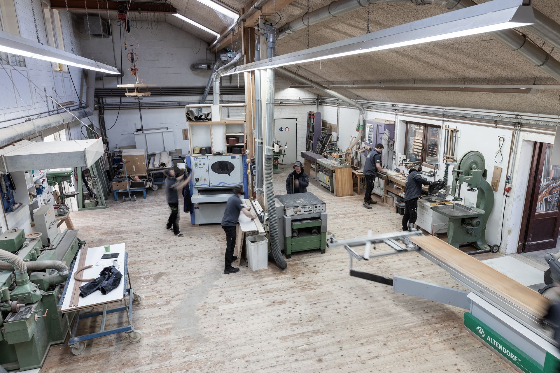 Eine Gruppe von Leuten arbeitet in einer Holzwerkstatt.