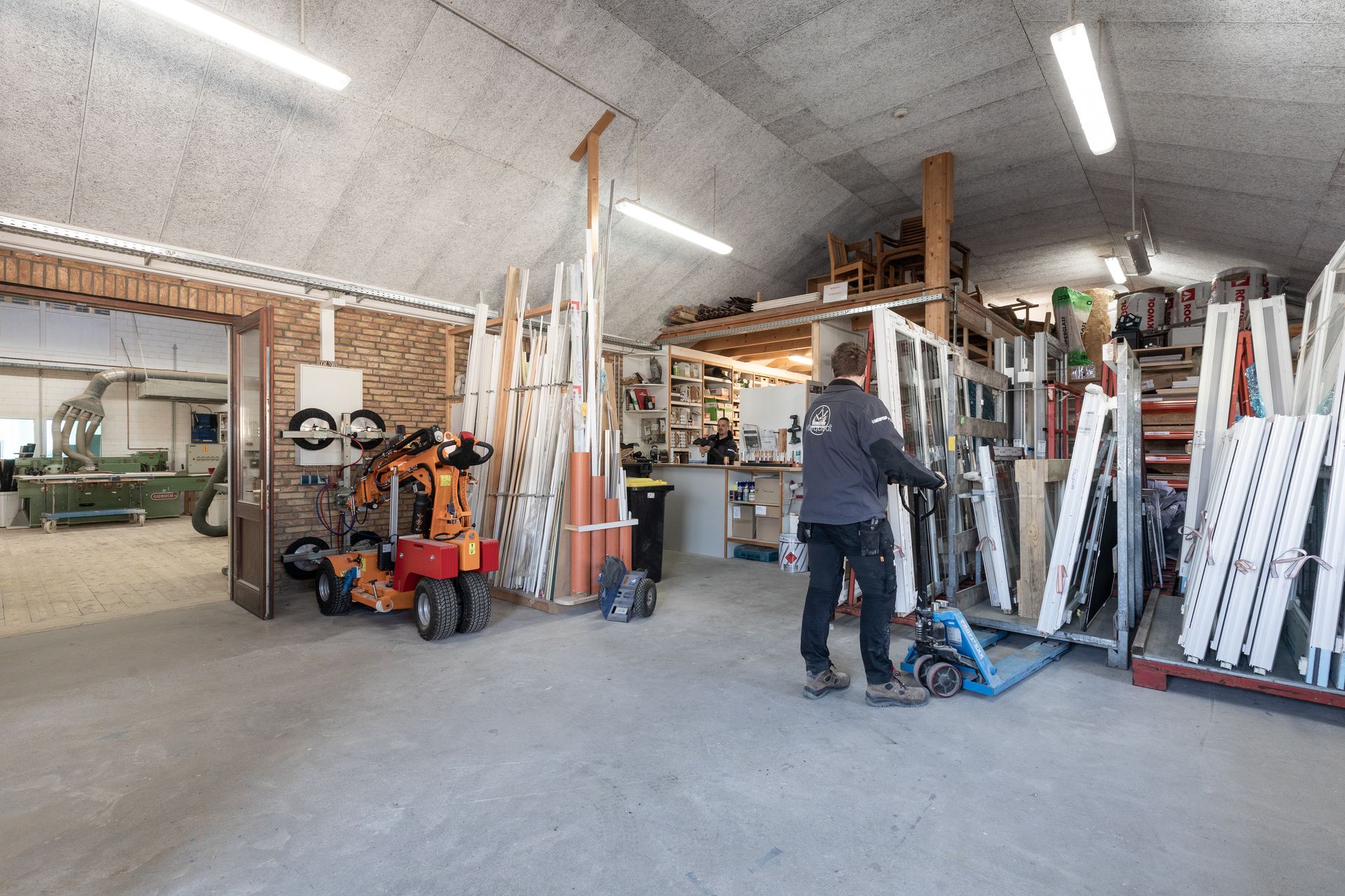 Ein Mann schiebt einen Hubwagen in einem Lagerhaus.