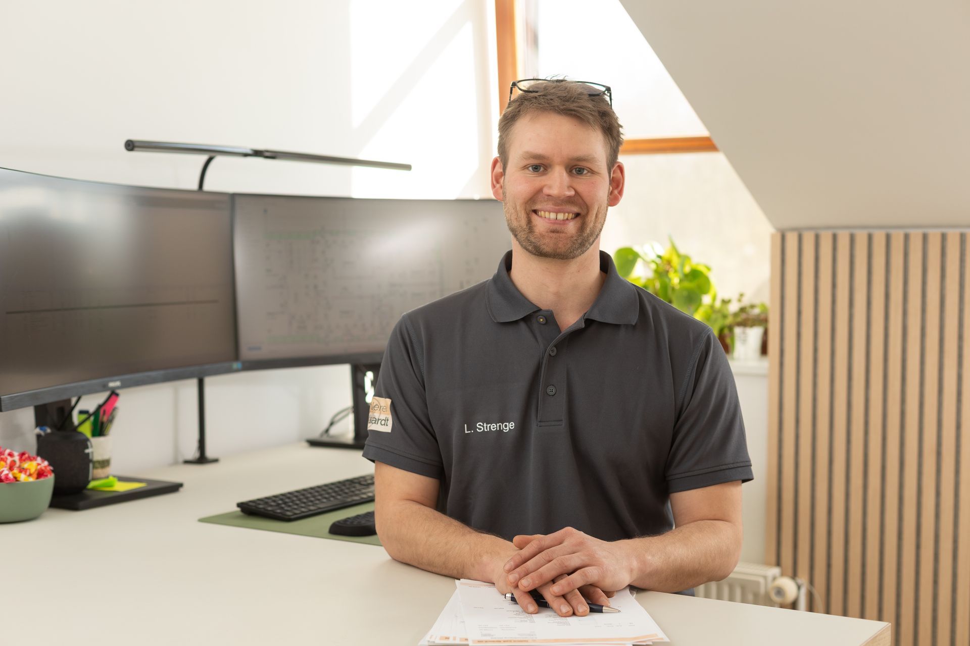 Ein Mann sitzt an einem Schreibtisch vor einem Computer.