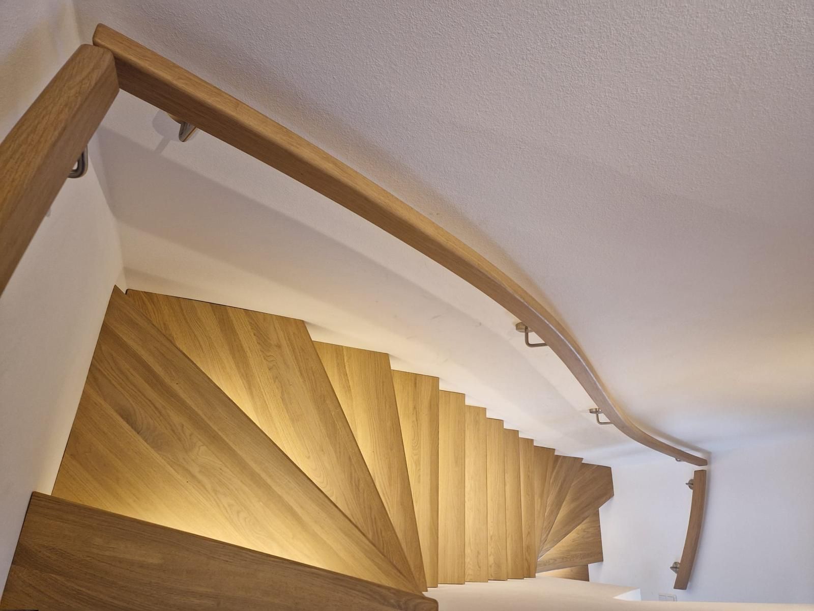 Eine hölzerne Wendeltreppe mit einem weißen Geländer