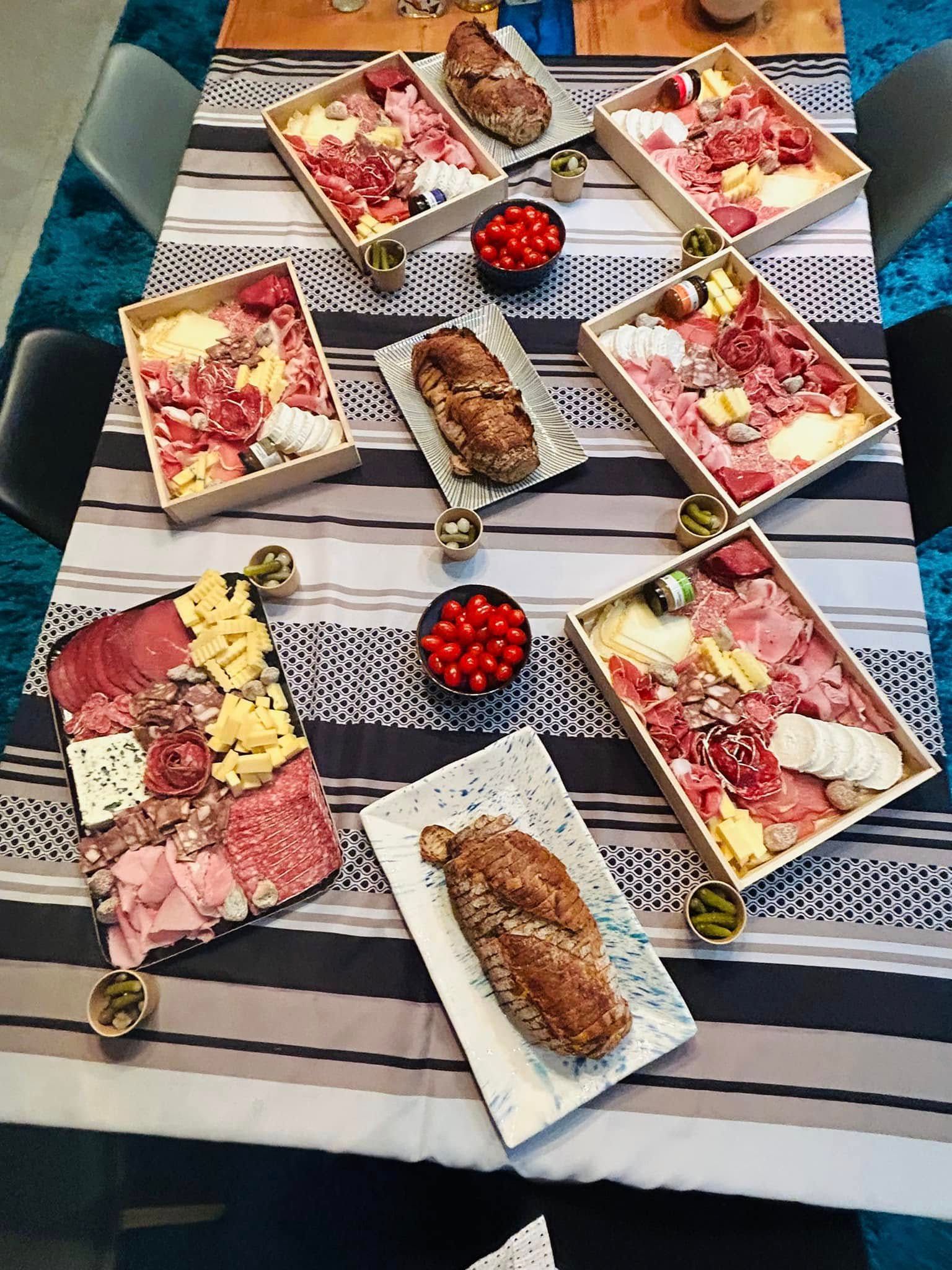 Dressage de table avec planches de charcuterie et miches de pain.