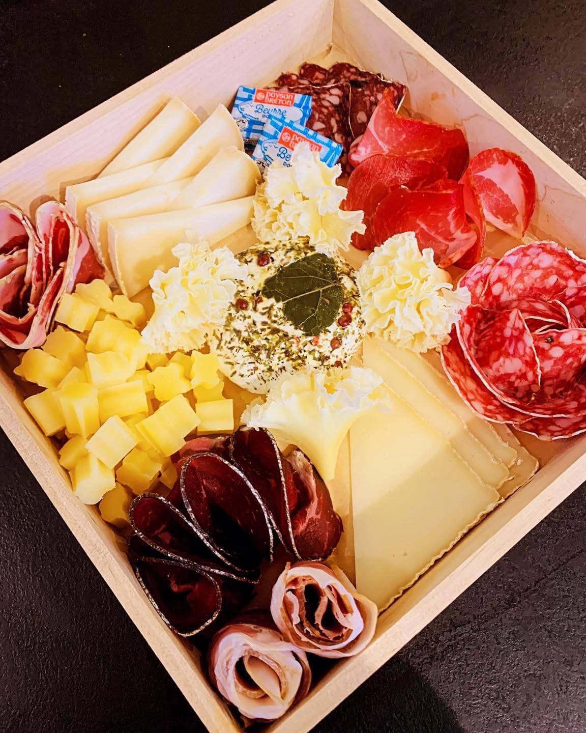 Coffret de charcuterie avec assortiment de fromages, viandes et en-cas.