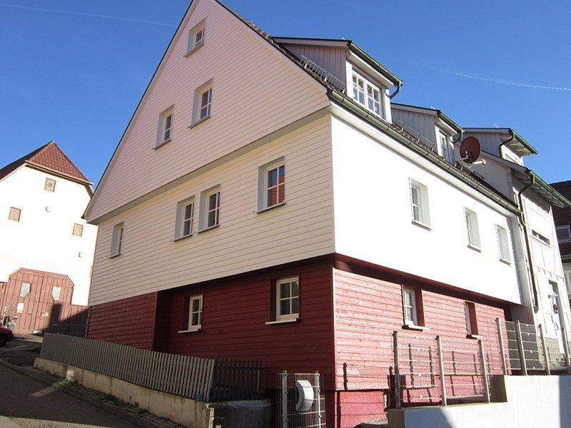 HB Holzbau Breymaier GmbH – Einfamilienhaus mit weißer und roter Fassadenverkleidung