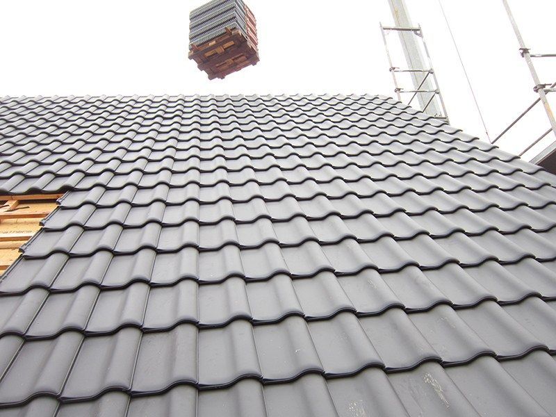 HB Holzbau Breymaier GmbH – dunkle Dachschindeln auf einem Schrägdach